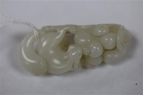 A Chinese white jade carving of a squirrel, grapes and lotus leaf, 18th/19th century, L. 6.4cm, wood stand